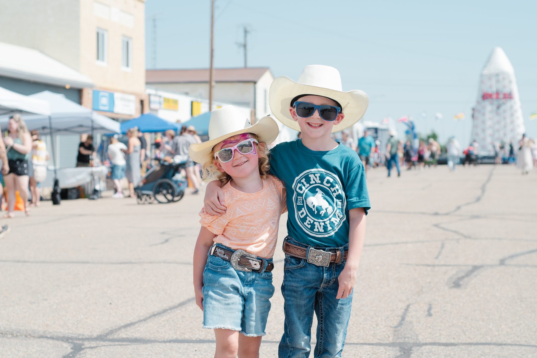 Two children on the main street of a small Alberta town during a summer street fair